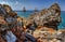 Seascape mountain rocks and blue sea with ships on horizon. Rocky stones on turkish beach in Alanya, Turkey