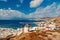 Seascape from Mykonos, Greece. Village windmill on mountain landscape by blue sea. White houses on cloudy sky with nice