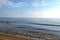 Seascape with passenger airplane ready to landing above the calm sea and sandy beach on sunny day