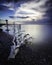 Seascape of a piece of Driftwood washed up along the coastline at sunset taken with a long exposure