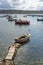 Seascape with pier, quiet sea harbor with clear transparent water and traditional greek fisher boats