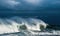 Seascape. Powerful ocean wave on the surface of the ocean. Wave breaks on a shallow bank. Stormy weather, clouds sky.