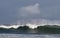 Seascape. Powerful ocean wave on the surface of the ocean. Wave breaks on a shallow bank. Stormy weather, stormy clouds sky