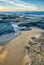 Seascape rocky beach entrance with sand, large rocks and boulders in calm sea water