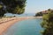 Seascape - sandy beaches of the Adriatic Sea against a bright blue sky, clouds, and a group of hotels Aman Sveti Stefan, Montenegr