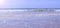 Seascape and sea with long big stormy waves in sand beach at sunny day.