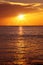 seascape with shiny sea over cloudy sky and sun during sunset in Cozumel, Mexico