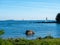 A seascape from the shore with sailboats sailing across the horizon