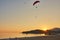 Seascape with silhouettes of the mountains and coast of sea at sunset. Paraglider flying over the beach of Oludeniz in golden