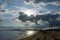 Seascape with silhouettes of trees and ships in the background light