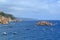 seascape with a small island in the sea and the boats of fishermen