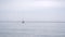 Seascape. A small yellow yacht bobs on the waves in cloudy stormy weather.