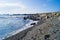 Seascape with stones. Blue sea and waves. Embankment and lighthouse.