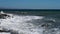 Seascape of stormy sea. Waves roll in and crash on coastal stones. Bright contrast video showing power and beauty of nature