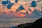 Seascape summer sunset at sea with rocks. Clouds over sea in orange light Evening sun. Loneliness landscape.