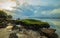 Seascape. Sunset at the beach. Ocean low tide. Rocks with green seaweeds. Cloudy sky. Horizontal background banner. Thomas beach,