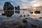 Seascape at sunset with clear water, corals, stones under water and large karst cliffs on the horizon.