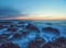 Seascape with sunset and rocks in a calm sea water