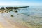 Seascape with a view of an old wooden breakwater with stones