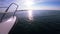 Seascape, view of sea waves with sun reflection from prow of motorboat.