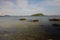 Seascape view with a small forested island on the horizon