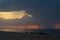 Seascape. Waves on the coast. Rain is pouring down from the cloud on the horizon. Thunderstorm front. Clouds and clouds