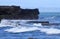 Seascapes at the south coast in Bali island of Indonesia,with rock formation,black sand and wave during day time