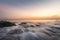 Seascapes with waves and rocks on the coastline at sunset