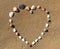 Seashell heart shape on the sand beach.