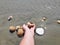 Seashell and sea stones hand fingers take catch seashell in water ocean water summer holiday tropical beach relax on day