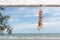 Seashell souvenir hanging decoration on wooden gazebo with tropical beach