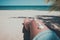 Seashell on tanned girl leg at tropical beach in summer