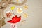 Seashells and nautical rope decoration on sand background with red toy ship