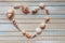 Seashells shaped heart on a wooden background top view