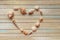 Seashells shaped heart on a wooden background top view