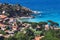 Seashore coastline with beach and little village in the Island of Elba in Italy. Many people on the beach sunbathing. Blue sea