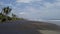 Seashore drone with palm trees with black volcanic sand, large waves and arrows in the sky