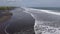 Seashore drone with palm trees with black volcanic sand, large waves and arrows in the sky