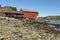 Seashore in ebb tide with a boathouse in background against a bl