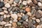 Seashore with gravel stone in summer, close up view. Texture of jackstone. Multicolour pebbles, abstract background.