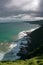 seashore and green ocean under dark clouds