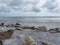 Seashore of Marina di Pisa beach with sailboats on the horizon in a cloudy day at summer. Tuscany, Italy