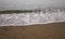 Seashore sand. Summer. Yellow sand and white waves.