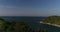 Seashore with trees and vegetation, birds fly over the sea