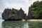 Seaside landscape with white sand beach and black cliff. Tropical coastline view of Palawan island, the Philippines