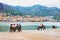 Seaside with people sitting on benches in Cefalu Sicily