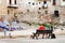 Seaside with people sitting on benches Cefalu Sicily