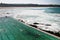 Seaside public Iceberg Club swimming pool. Idyllic and amazing landscape of jagged shoreline with rocks, white rushing ocean waves