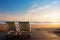 Seaside serenity Bench on beach at golden sunset, tranquil beauty