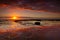 Seaside sunrise and vivid textured rock reflections